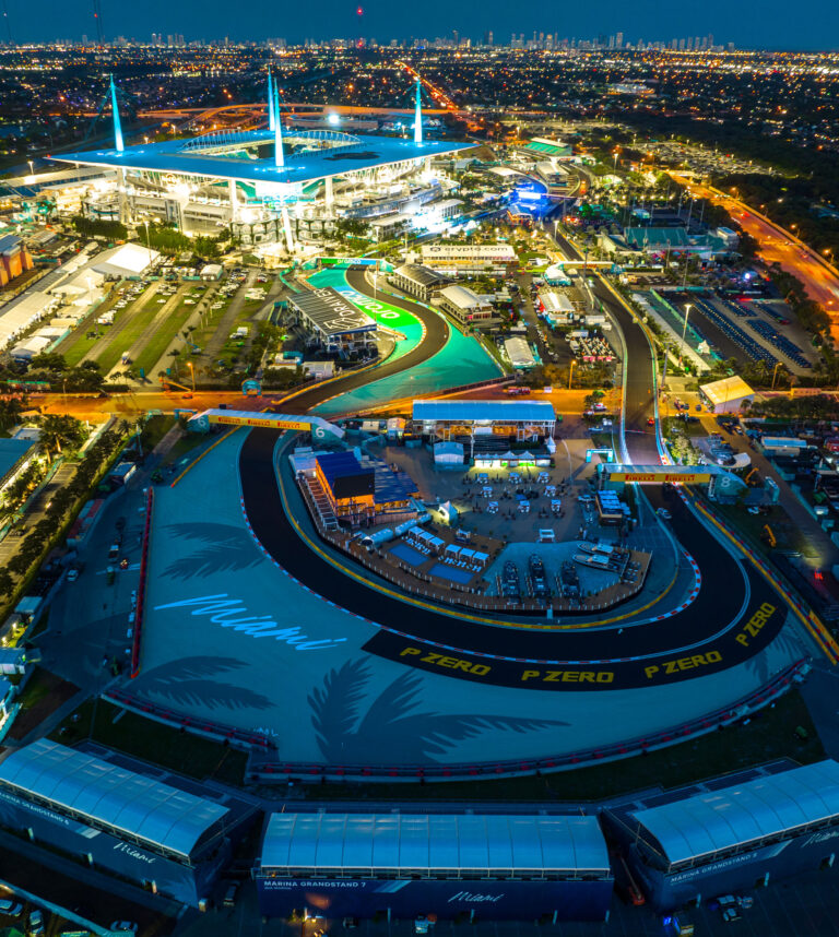 Aerial view of a Miami race circuit lit up at dusk, by Arte City Media