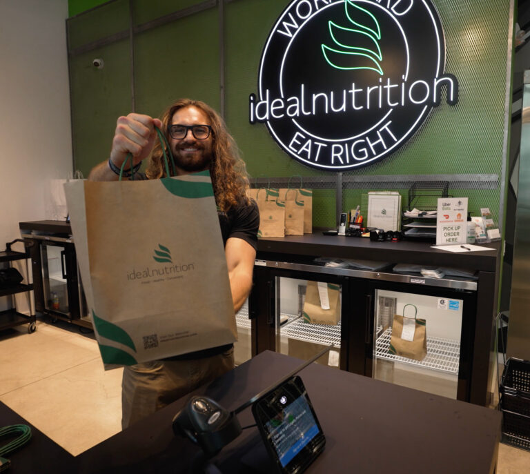 Store owner holding a branded bag in a promo video