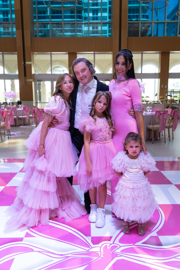 Family celebrating a bat mitzvah in matching pink outfits