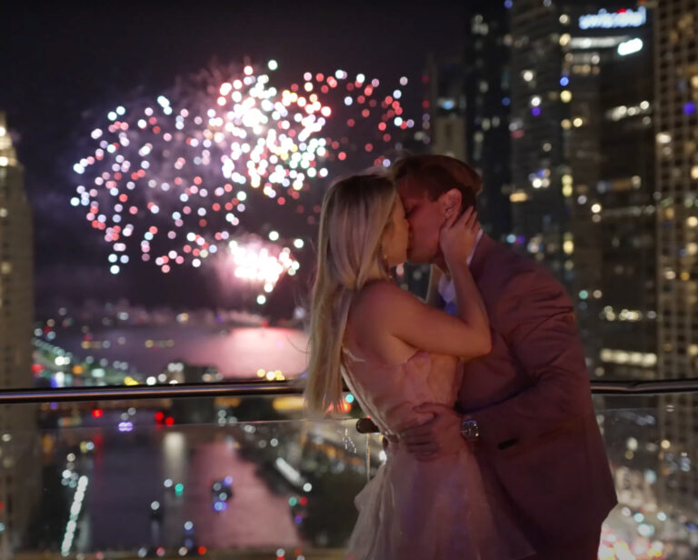 Newlyweds kissing under fireworks at their reception