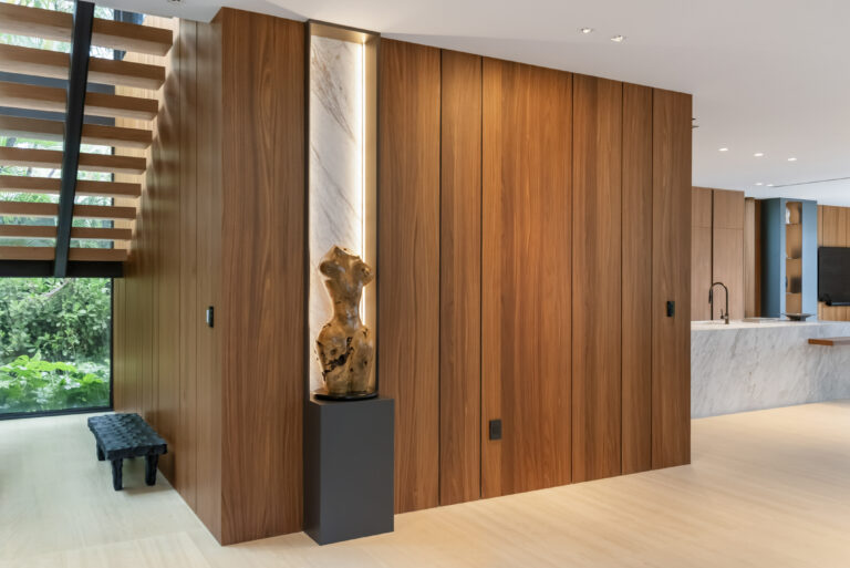 Luxury modern home interior with walnut walls and a floating staircase