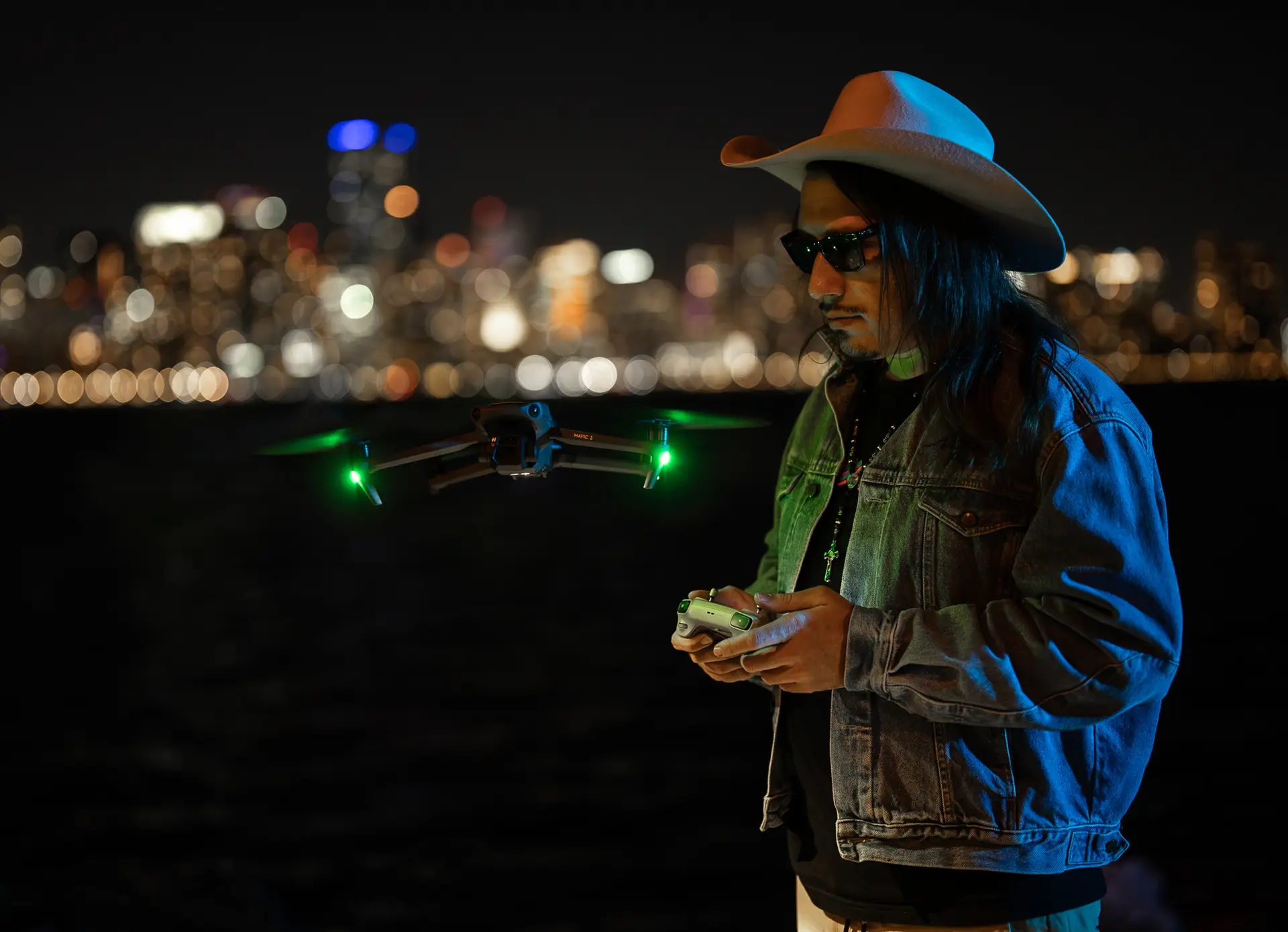 Matthew Hoyos flying a drone at night with the Miami skyline behind him