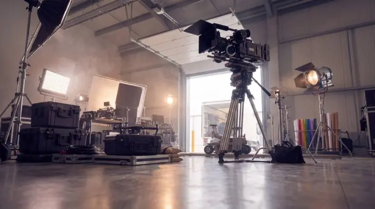 Low-angle view of film production gear on a soundstage with a grip truck at the loading door