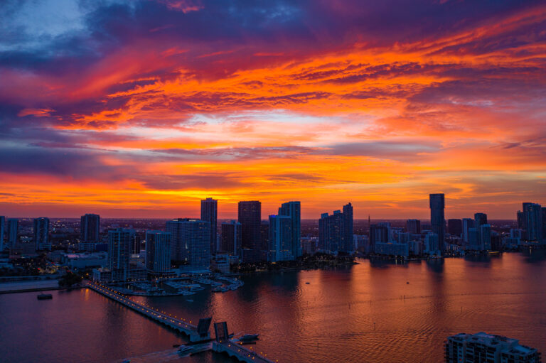 Aerial view of the Miami skyline under a vibrant pink and orange sunset, by Arte City Media