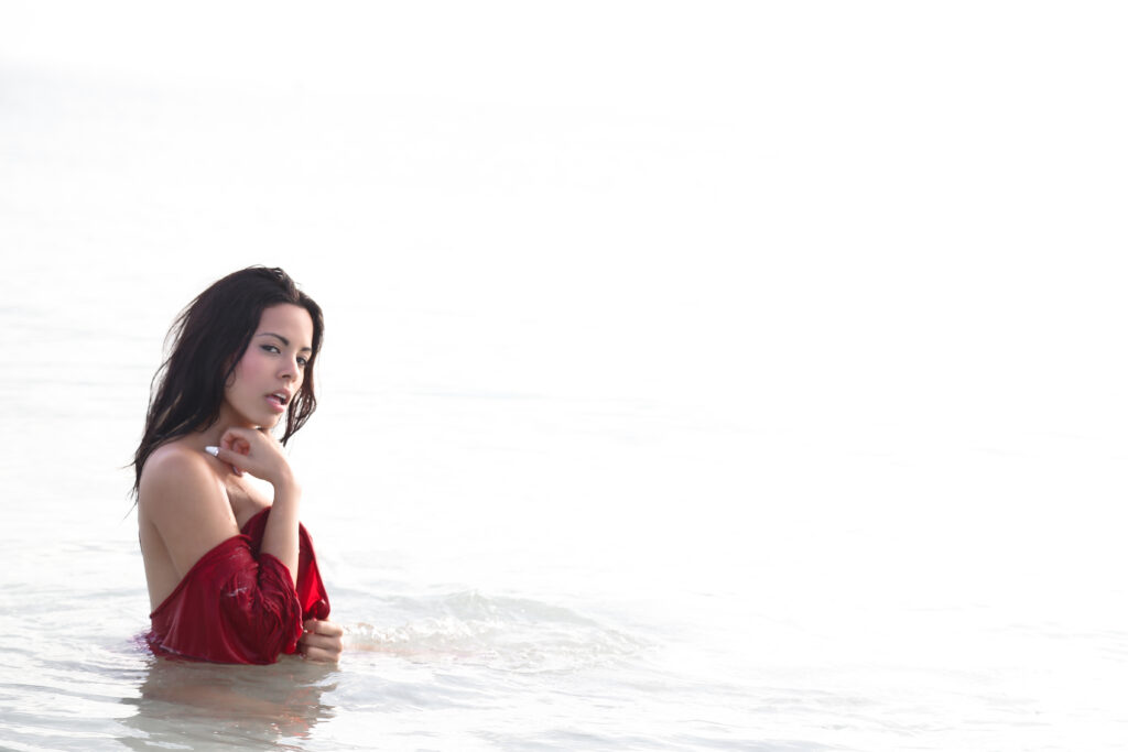 Model in a red dress standing in the water