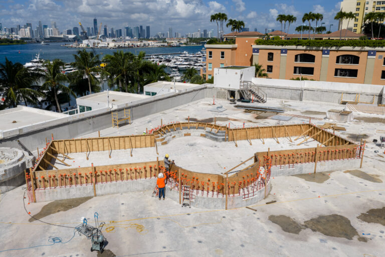 Drone view of rooftop pool construction with the Miami skyline in the background, by Arte City Media