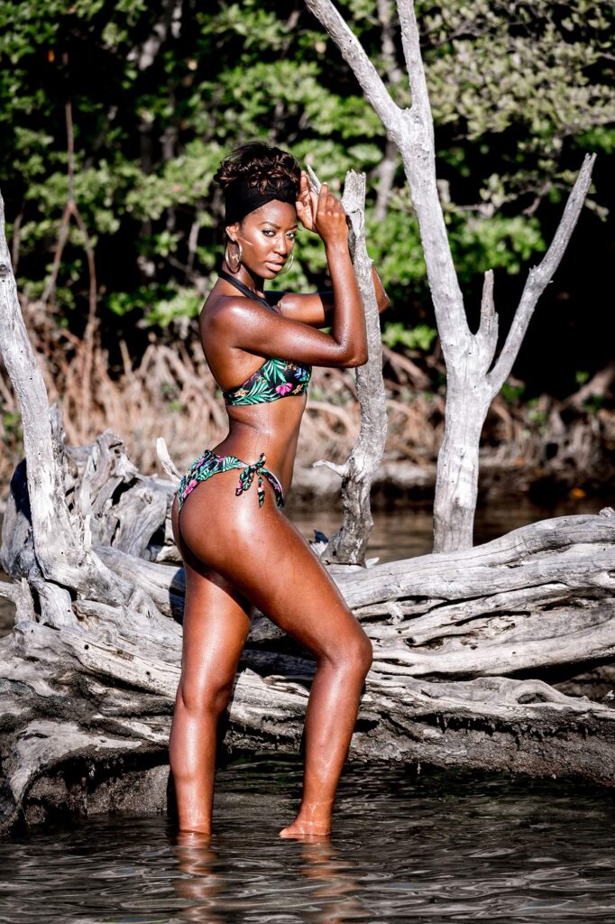 Model posing on driftwood by the water