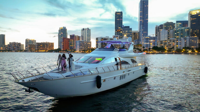 Luxury yacht cruising Biscayne Bay at dusk with the Brickell skyline, by Arte City Media